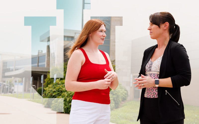 Two colleagues have a discussion outside a building