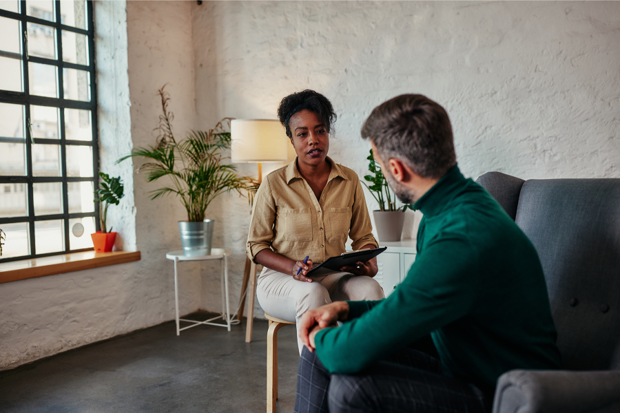 A psychologist and a patient sit and talk in an office