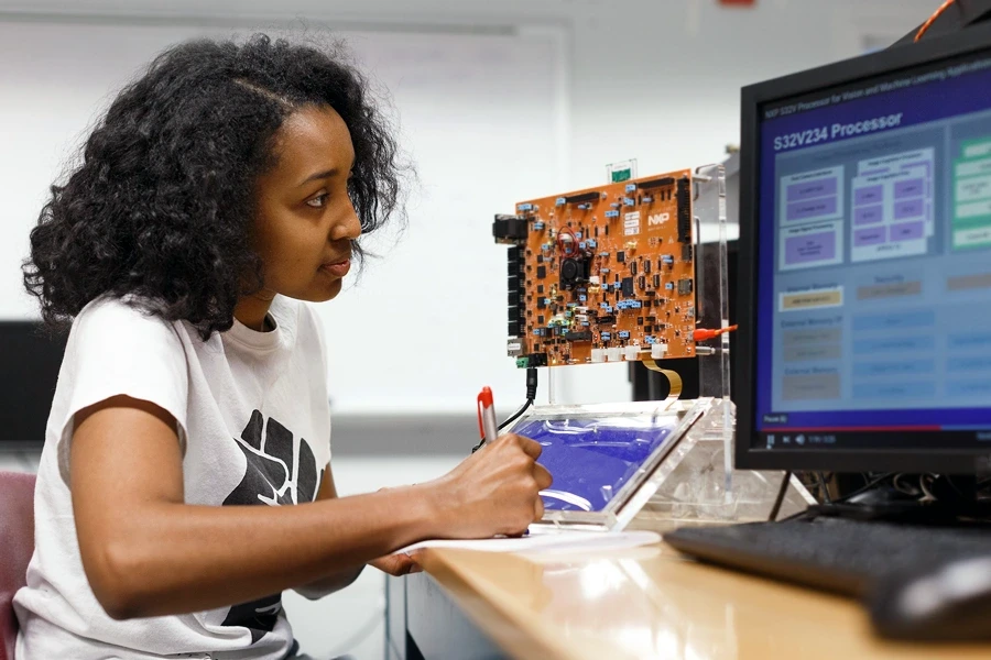 A woman takes notes on programming.