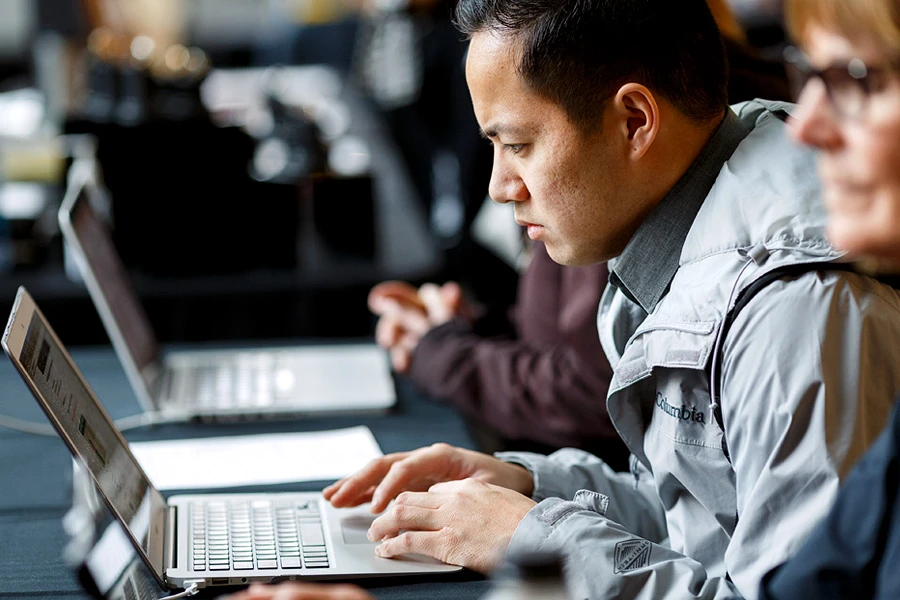 A man looks intently at content on his laptop.