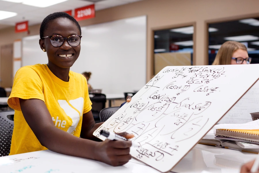 A student shows off a whiteboard with trigonometry formulas