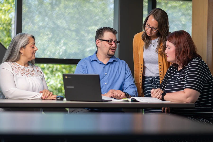 A group of social workers have a discussion around a table