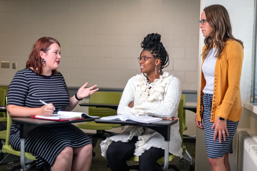 A group of social workers converse in a school setting