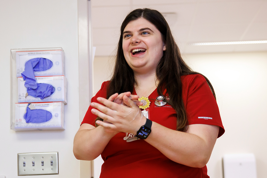 Image of Courtney Waskow wearing scrubs and washing her hands