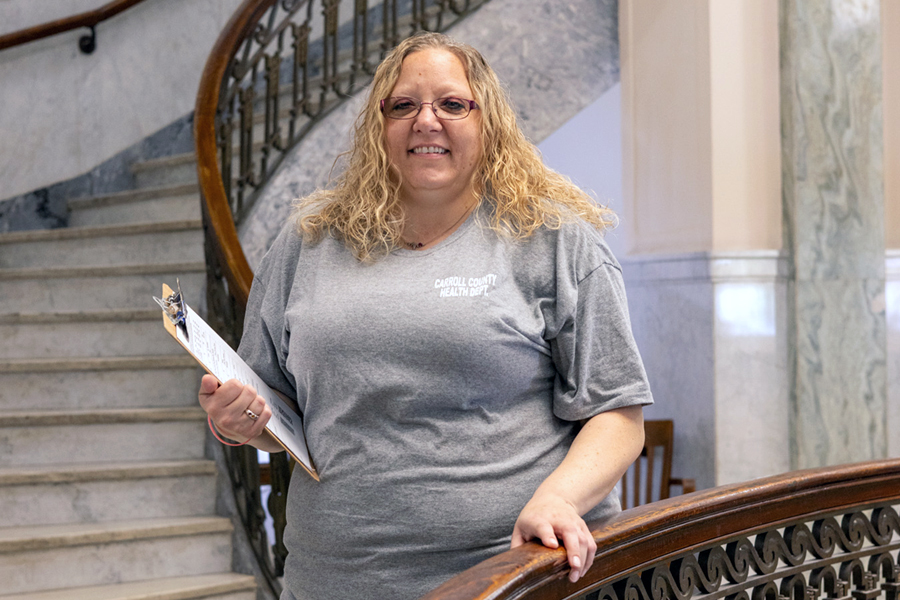 Image of Julia Hoskins standing with a clipboard in the courthouse where she works