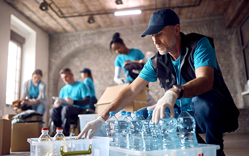 A group of volunteers organize donations of water bottles.